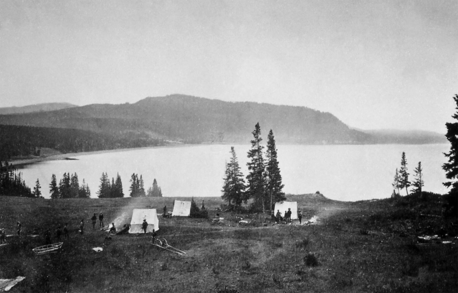 “Earthquake Camp” at Yellowstone Lake. In the foreground at left are the frame of the Annie and, left of center, the odometer cart. The group felt several earthquakes while camped here, causing horses and men to suddenly leap to their feet. William Henry Jackson photo, 1871., U.S. Geological Survey via the National Park Service.
