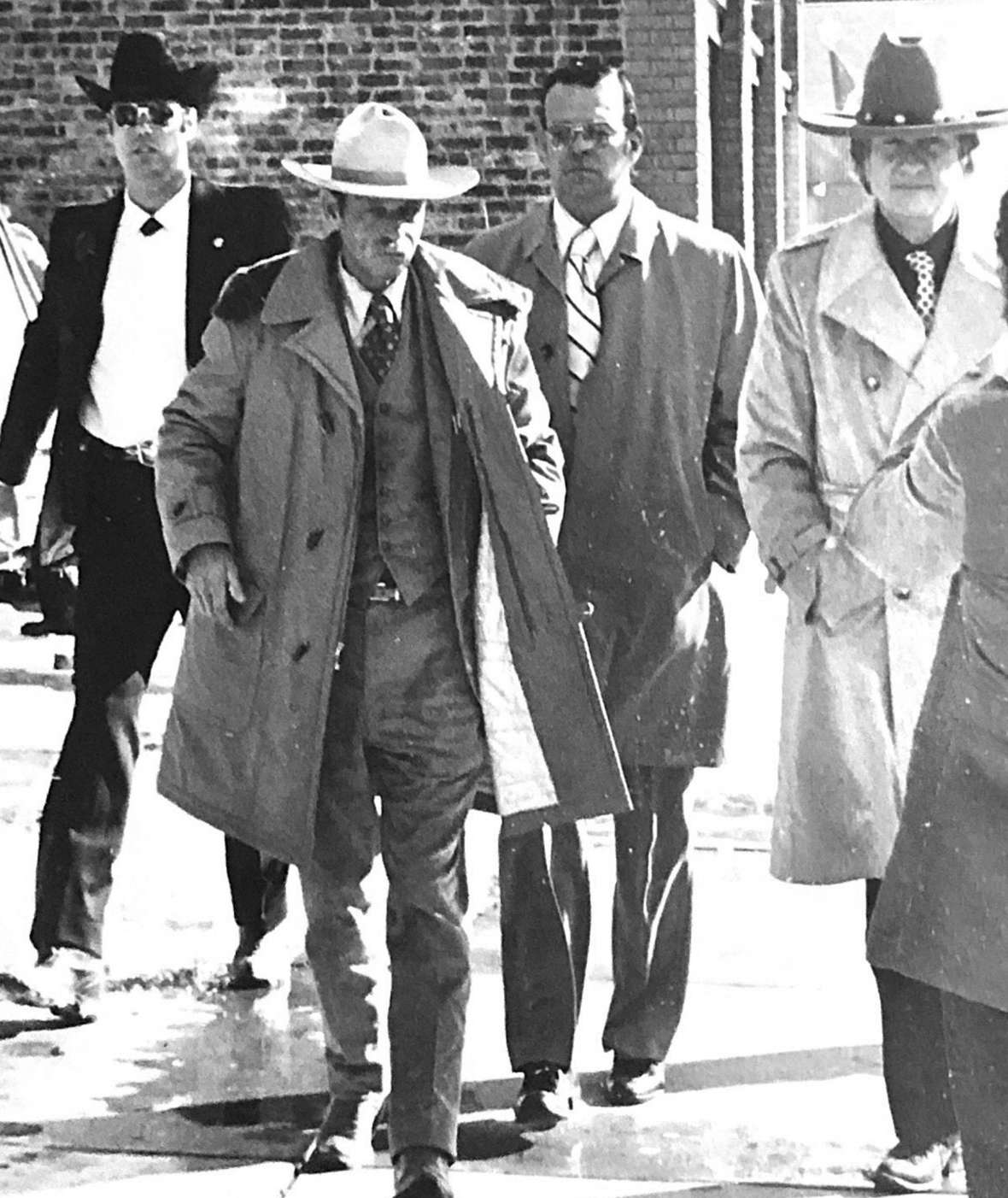Escorting Ed Cantrell, second from left, to the first day of the preliminary hearing are Rock Springs police officer Dan Zeigler, police Lt. Robert Overy and, at far right, Cantrell’s lawyer, Gerry Spence. Author photo.