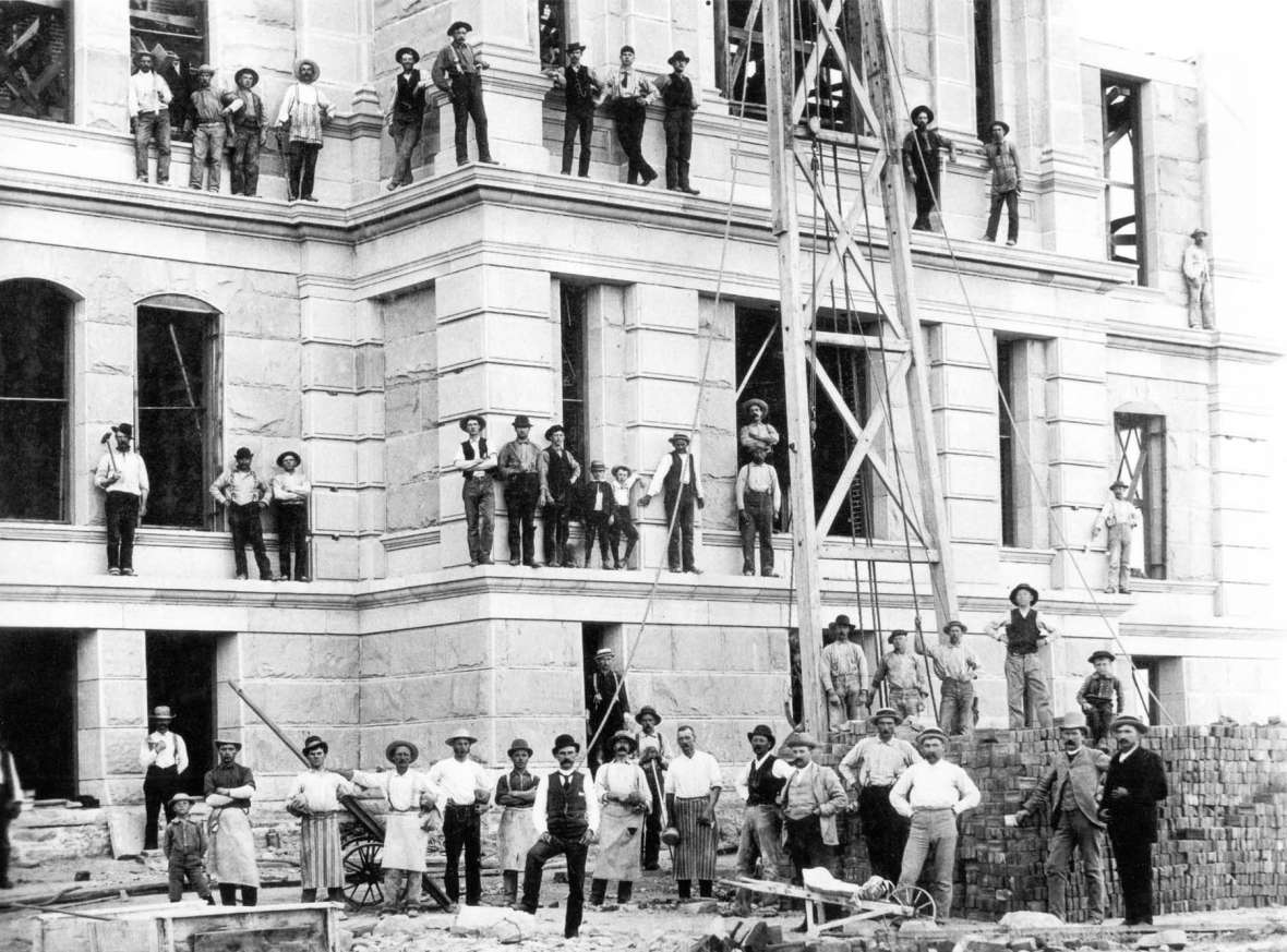 Workers on the walls and roof during construction of the Capitol’s first addition, ca. 1889, which added wings to the east and west sides of the building. Wyoming State Archives.