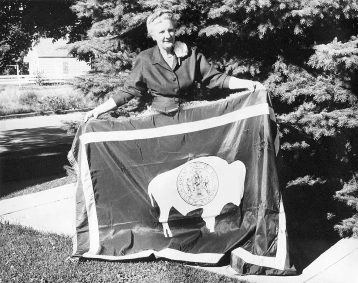 Verna Keays holds the Wyoming state flag, around 1960. She designed the flag four decades earlier. Wyoming State Archives.