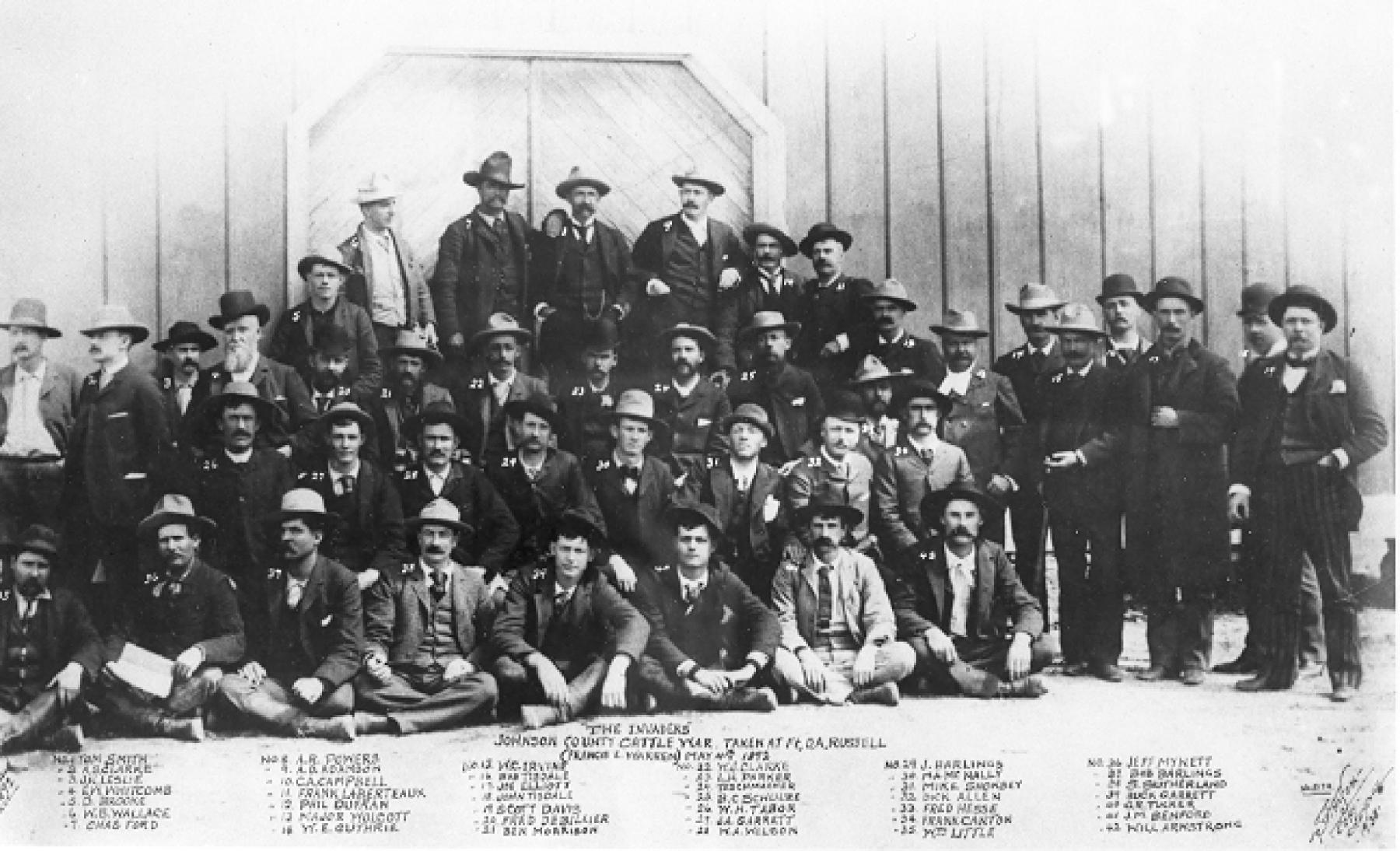 The invaders of Johnson County, in custody at Fort D.A. Russell outside Cheyenne, May 1892. Frank Canton is No. 34, seated at the right-hand end of the second row. Canton's and expedition leader Frank Wolcott’s insistence that the group detour to the KC Ranch to kill Nate Champion led to delays that spelled failure for the expedition’s main goals. They had planned to murder dozens more people in Johnson County. Wikipedia.