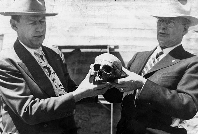 The two halves of Big Nose George Parrott's skull were briefly reunited in 1950. Lou Nelson, right, was the husband of Dr. Lillian Heath, who had kept the top half since the time of Dr. Thomas Maghee's original post-mortem investigation of Parrott's brain. The bottom half of the skull turned up in a buried whiskey barrel with the rest of the outlaw's bones. On the left is Ben Sturgis, Carbon County coroner. Carbon County Museum.