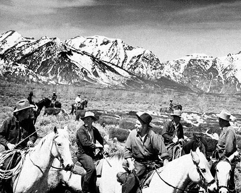 Armed ranchers, including Teton County Commissioner Clifford Hansen, left, and actor Wallace Beery, in black hat, trail cattle in protest across the newly created Jackson Hole National Monument, 1943. AP photo.