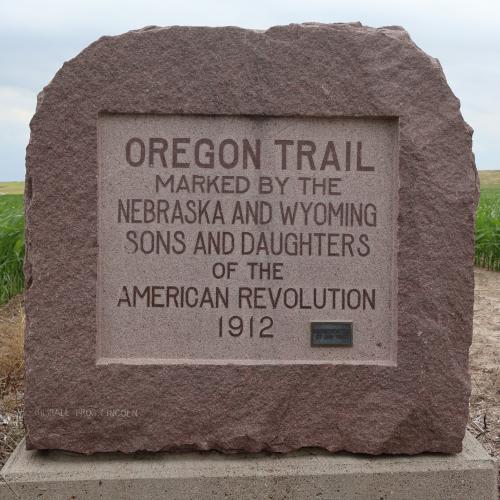 This red granite monument, marking an Oregon Trail location, was placed  on private property on the Nebraska-Wyoming border near Scottsbluff in  1912. The Nebraska and Wyoming Sons and Daughters of the American  Revolution plus the Nebraska State Oregon Trail Memorial Commission  spearheaded the effort. Photo by Kylie Louise McKormick. 