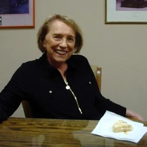 Kathy Karpan smiling and sitting at a table