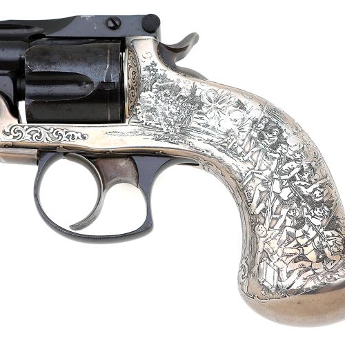 detail of revolver showing closeup of battlefield etching on silver grip