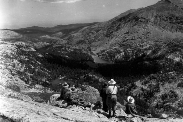 Looking west from the Bighorns near Cloud Peak down the Paint Rock drainage toward the Bighorn Basin. Lake Solitude is at the center of the photo in the middle distance. The photo was taken by Elsa Spear Byron of the Spear-O-Wigwam dude ranch; the people in the foreground are most likely dudes who came over Geneva pass and into the drainage on a pack trip—the same route Howard Zahniser and the Schunks would use in the next decade. The Wyoming Room, Sheridan County Fulmer Public Library.