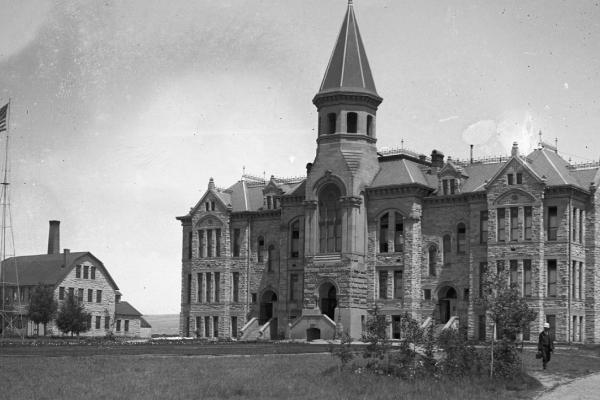 Old Main building at the University of Wyoming, a stone building of at least three floors, with a large steeple-like tower over the main entrance