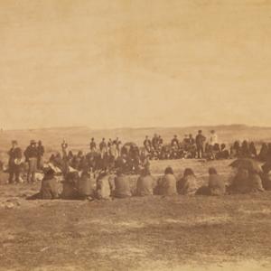 Apsáalooke (Crow/Absaroka) people receiving presents from the Indian peace commissioners at Fort Laramie, 1868. William T. Sherman collection of Gardner photographs; NMAI.
