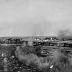 View of Saratoga and the Saratoga-Encampment Railroad, with the hot spring pools visible alongside the tracks. The railroad reached Saratoga in 1907. Courtesy Saratoga Museum, P1975.001.081, donated by Historic Reproductions by Perue.