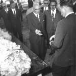 Zahir Shah, king of Afghanistan, reaches for a wool sample as the royal tour paused briefly by the sheep pens at the UW stock farm, August 1963. American Heritage Center.