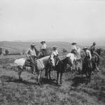 Dudes enjoy each other and the the view from a ridgetop above Eatons' Ranch west of Sheridan, ca. 1920. American Heritage Center.