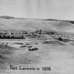 A bird's-eye view of Fort Laramie in 1889, the year before the U.S. Army closed it. The Laramie River flows between the tents and wagons in the foreground and the fort buildings in the background. American Heritage Center.