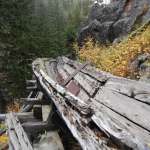 An intact segment sweeps around the first large curve near the west, or upper, end of the flume. Portions of the walkway also remain, as do sporadically placed steel plates used to reinforce or patch the wooden structure. E. Rosenberg, 2010.