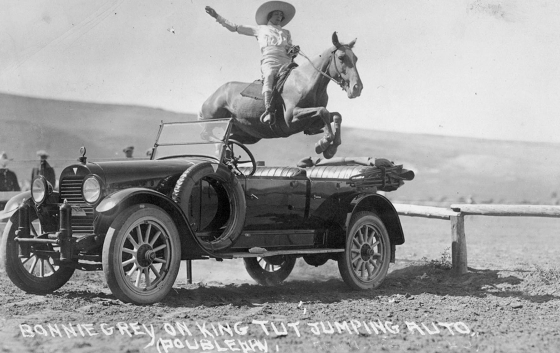 Tourist postcards became widespread after World War I, with the advent of the automobile culture. Here, Bonnie Grey in Wyoming jumps a car on her horse, King Tut, in the mid 1920s. Wyoming State Archives.