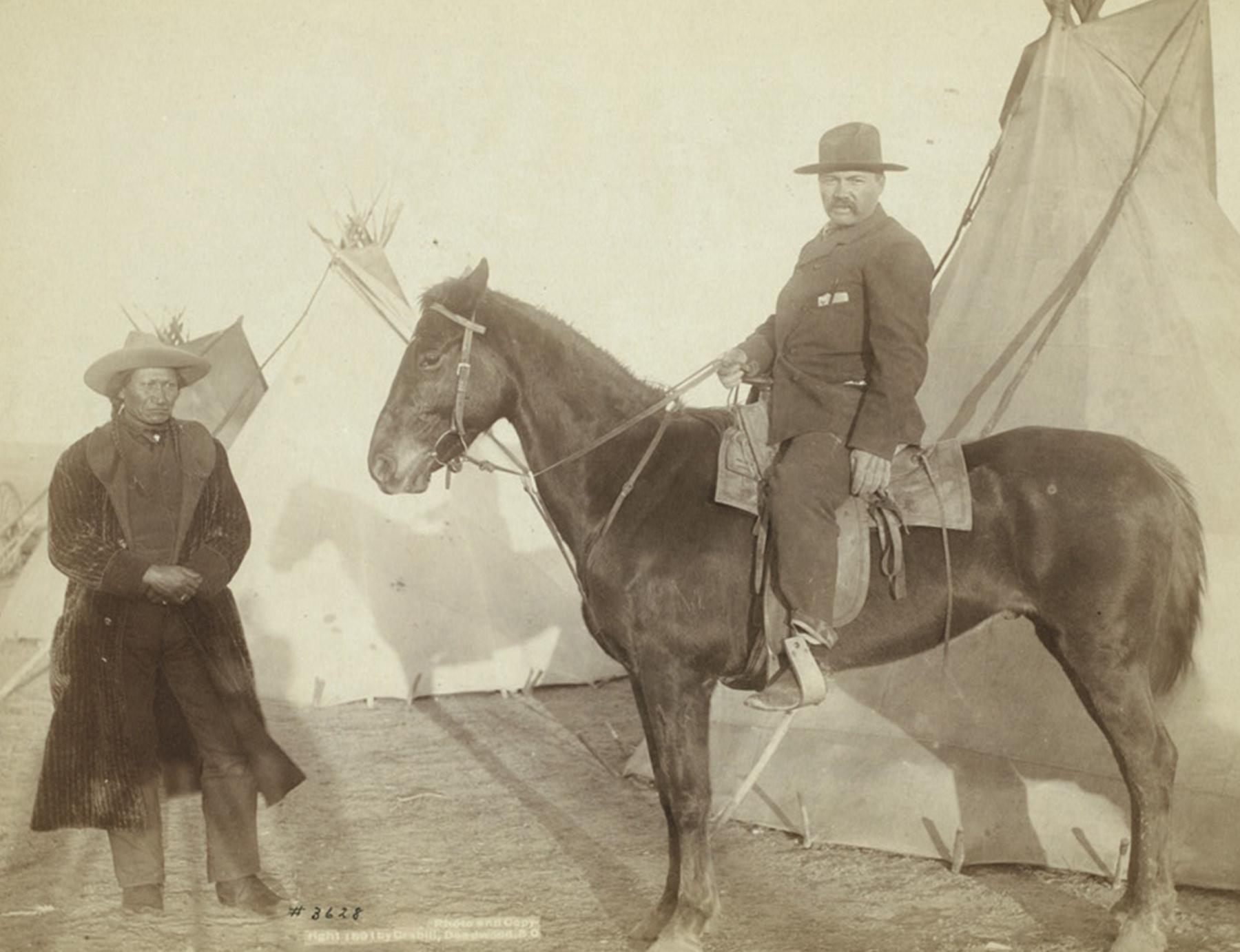 This photo of Grouard at the home of the Oglala Chief Rocky Bear, left, was taken in 1891, probably on the Pine Ridge Reservation, by Black Hills area photographer John Grabill. Grouard’s life from mail carrier, to captive, to adopted brother to Sitting Bull, to scouting for Crook in his campaigns against the Lakota, reveals the complicated relationships and loyalties of the changing West. Library of Congress.
