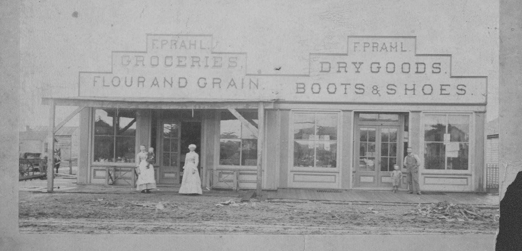 F. Prahl’s store in downtown Laramie in 1883, the year Monte and John Grover married. Brothel workers like Monte would shop with their cash-based business, contributing to the local economy during the 1880s. Photo files, American Heritage Center, University of Wyoming. Old photograph of storefronts with two women in long dresses, one holding a baby, and a man and child standing in fron ton w wooden sidewalk. The stores' signs say "F. Prahl Groceries Flour and Grain" and F. Prahl Dry Goods Boots & Shoes"