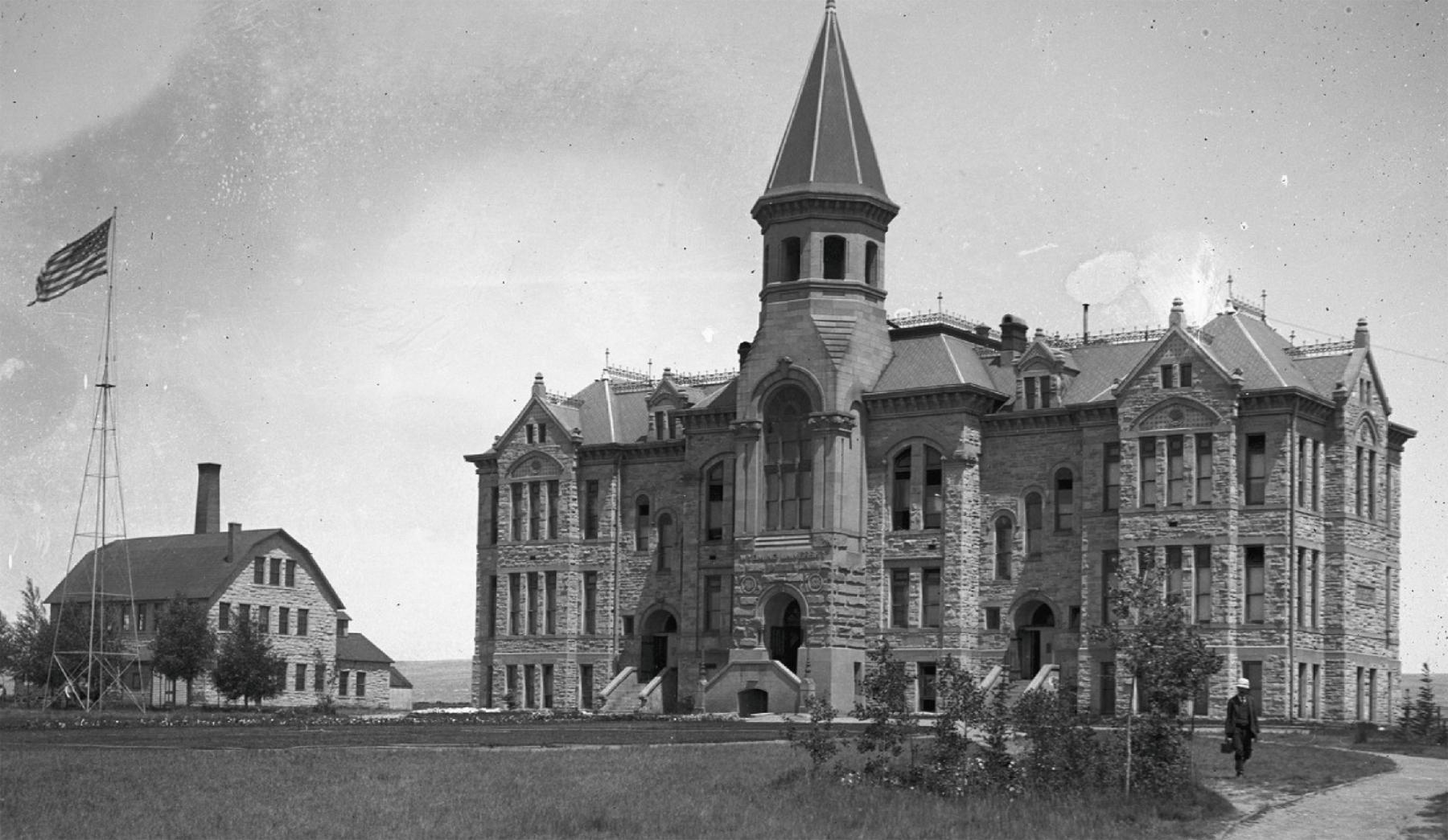 Old Main building at the University of Wyoming, a stone building of at least three floors, with a large steeple-like tower over the main entrance