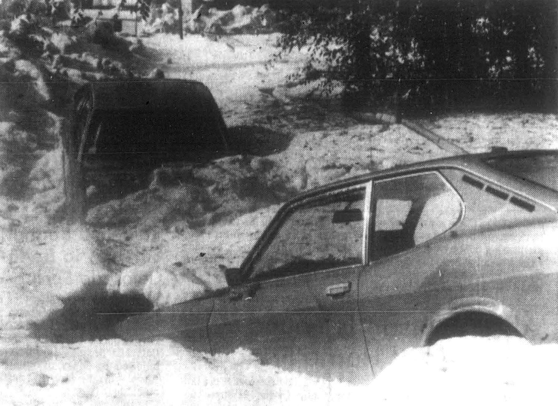 Two cars sit buried in a mixture of rain and hail on Pershing Boulevard during the storm. The massive hailstones, some measuring up to two inches in diameter, accumulated in drifts nearly 10 feet high and left vehicles stranded throughout the city. cars buried in hail drifts