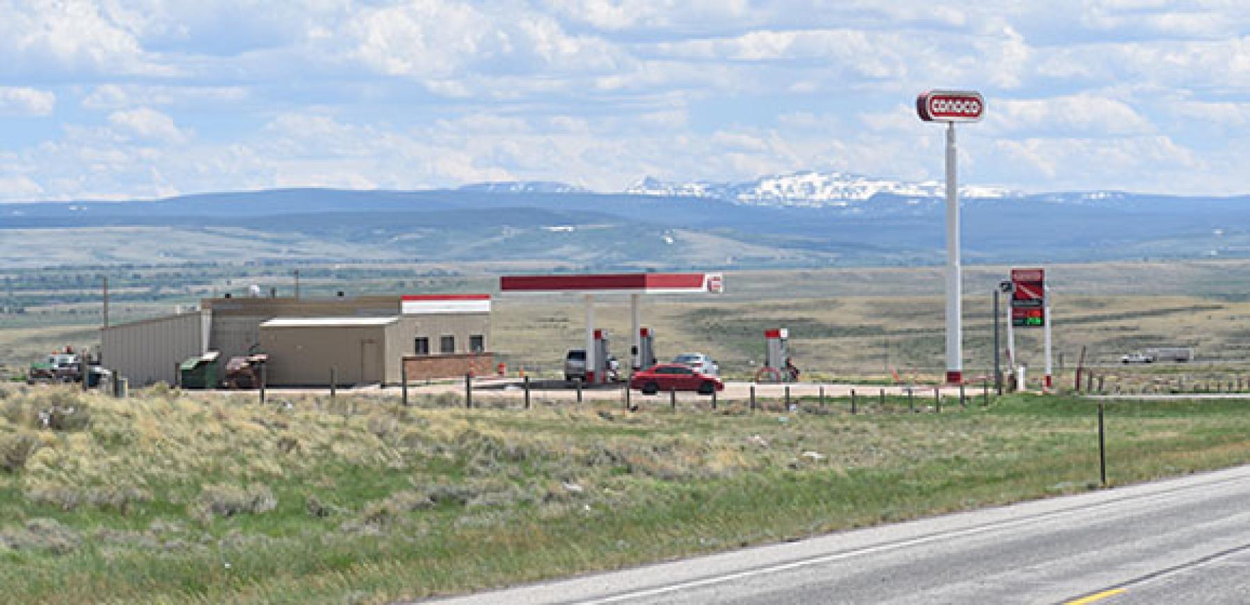 near the Elk Mountain Interchange, July 2020 Conoco Station in a vast open praiarie next to a highway with mountains in the far-off distance.