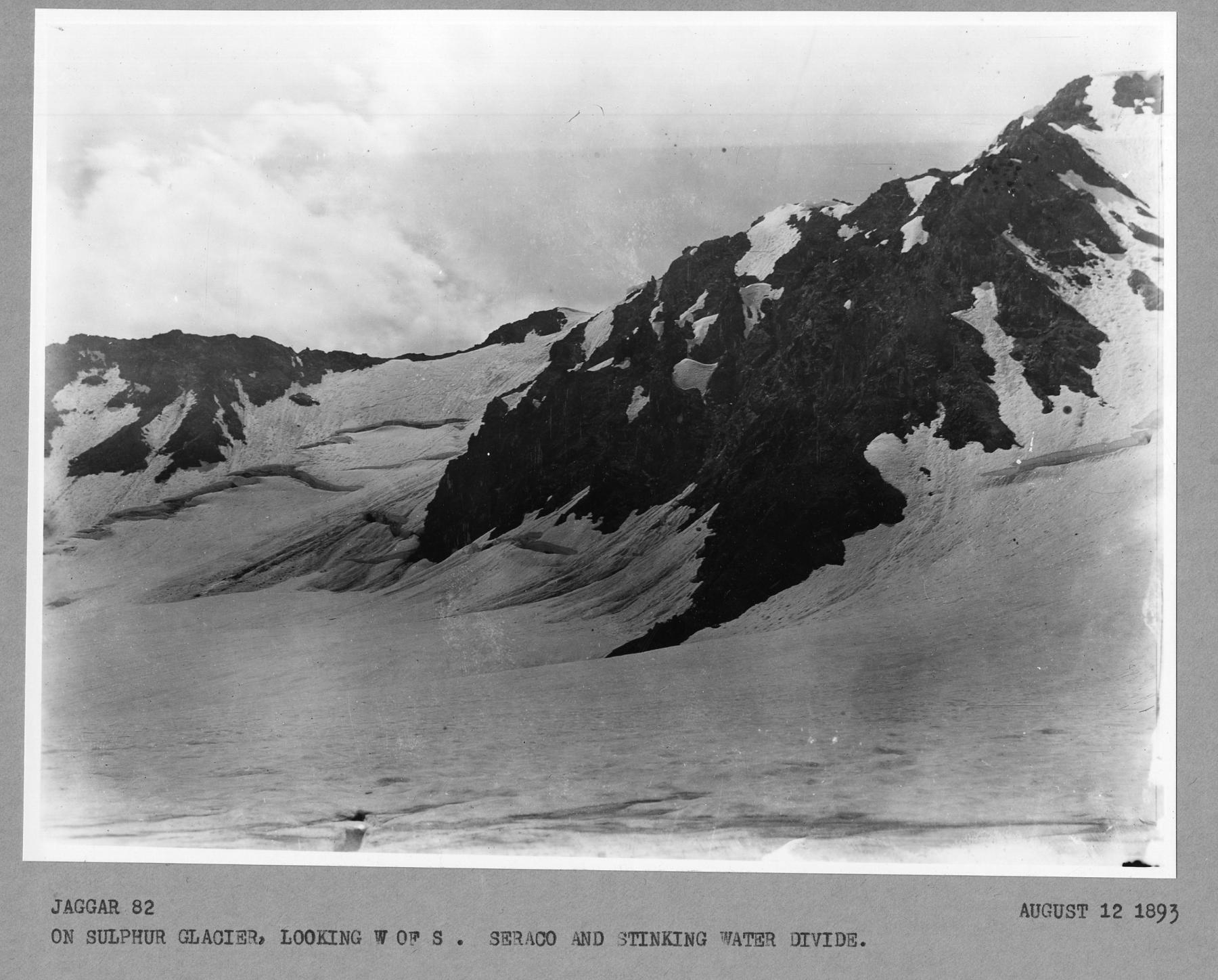 black and white photo of craggy mountains emerging from a thick snowfield