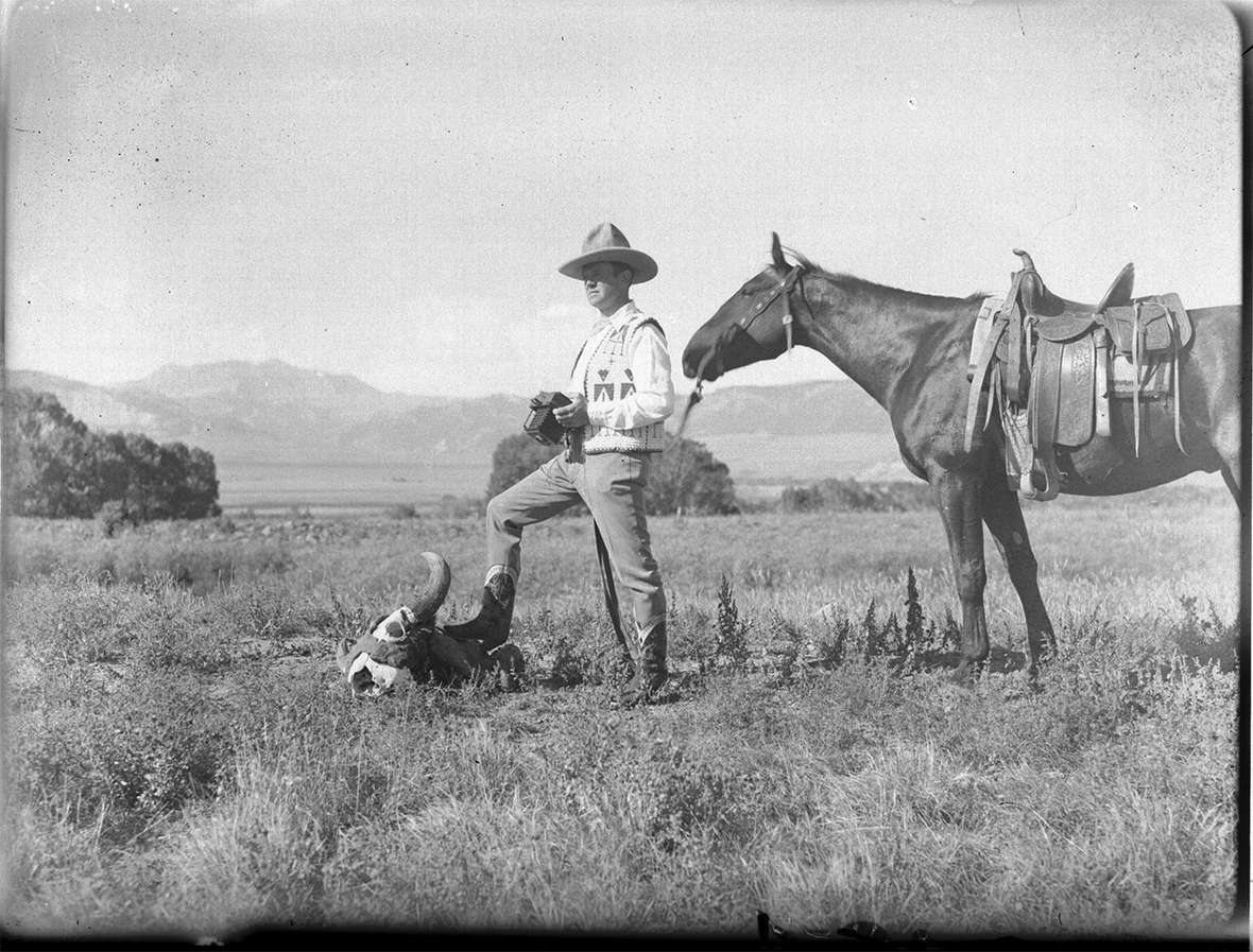 Cowboy photographer Charlie Belden, shown here in what amounts to a self portrait probably from the 1930s, had a keen sense of drama and design. He’s holding what may be the same large-format (4x5) but portable  Zeiss Minimum Palmos camera he used on his 1909 tour of Europe and Russia.  American Heritage Center. 