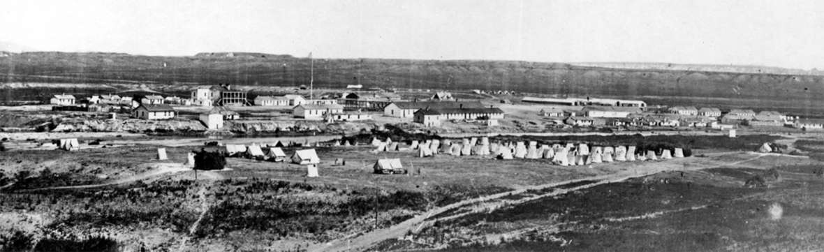 Fort Laramie in 1870, three years after John Hunton first arrived in the area and went to work supplying firewood for the soldiers. Army tents in this view are on the near side of the Laramie River, with the buildings of the fort beyond it. William Henry Jackson photo.