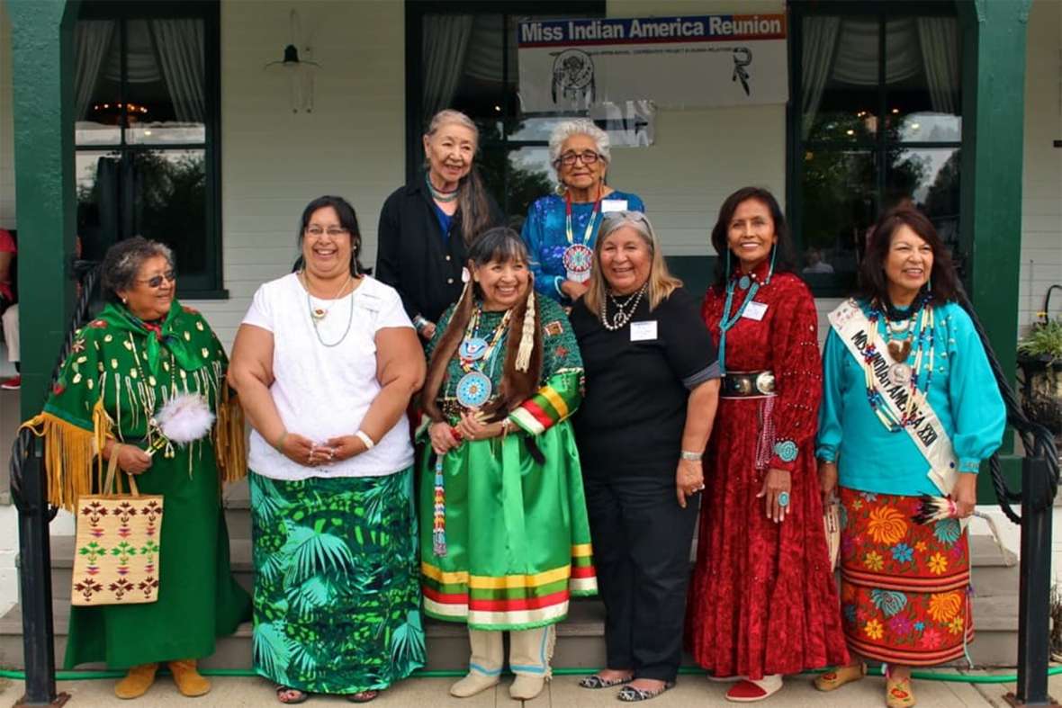 Miss Indian America winners reunited at the Sheridan WYO Rodeo in 2013 and 2015. Shown here in 2015, front row, left to right: Arlene Wesley (Yakama), MIA 1953; Annita Jo Wolf Black representing her mother, Brenda Bearchum (Northern Cheyenne-Yakama), MIA 1961; Williamette Youpee (Sisseton-Yankton Sioux), MIA 1963; Sharon Ahtone Harjo (Kiowa), MIA 1965; Sarah Johnson Luther (Navajo), MIA 1967; Deana Harragarra Waters (Otoe-Kiowa), MIA 1975. Back row, left to right: 1954 Miss Indian America runner-up Annie Grace Strange Owl (Northern Cheyenne); Jewel Medicine Horse Williams (Crow), secretary to Howard Sinclair. Gregory Nickerson photo.
