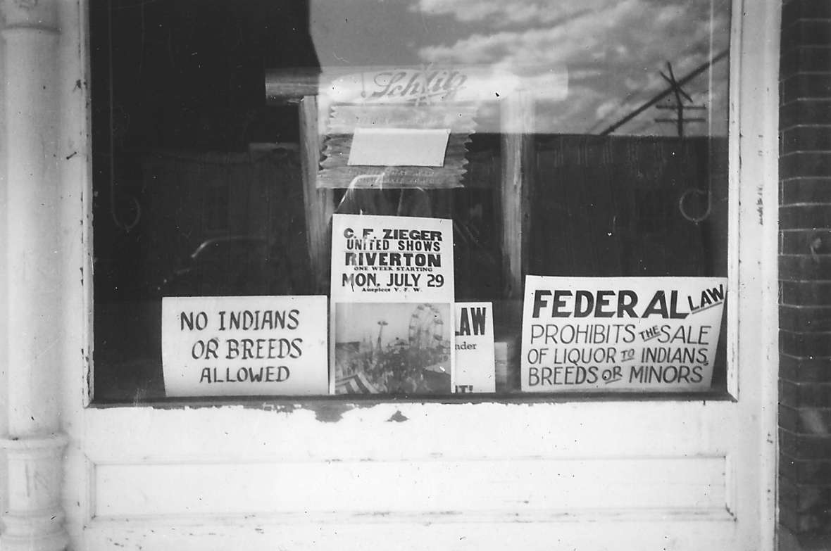Signs like this in the window of a Lander, Wyo., bar in 1934 were not uncommon in towns bordering reservations in the American West. The location is 126 Main St., today’s Lander Bar. Lander Pioneer Museum.