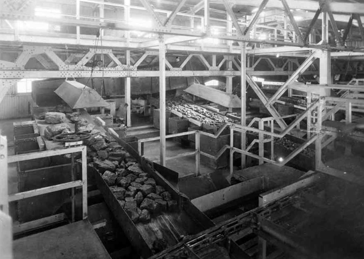 Inside the steel tipple, completed in 1936, a series of shakers and screens sorted the coal into four sizes: powder, nut, egg and lump. But the “boney—“ slate and other impurities—had to be picked out by hand. Shown here, a chute of lump coal. Sweetwater County Historical Museum.