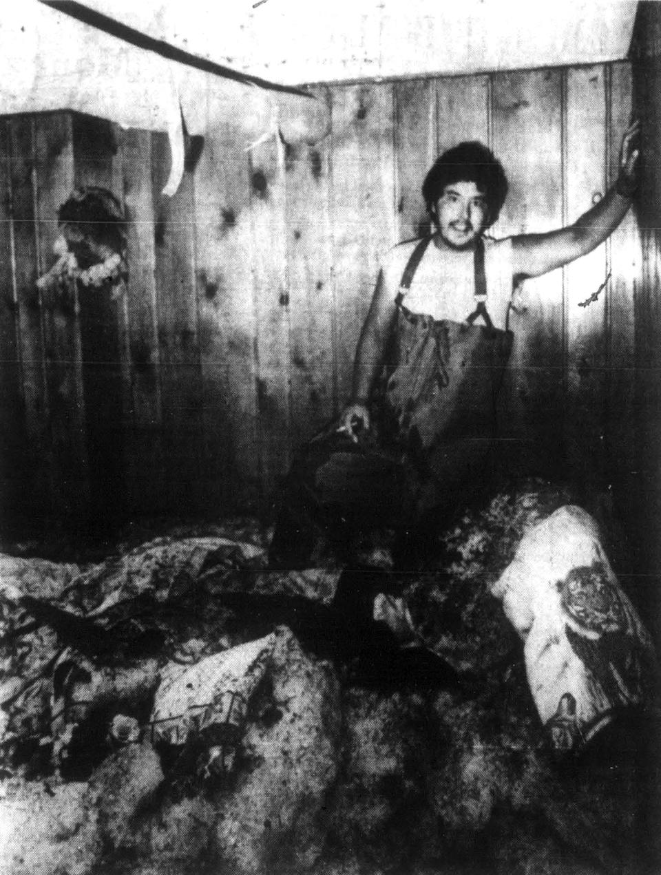 man in waders stands on a pile of hail in a shed