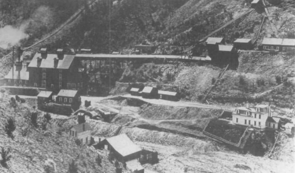 Mansard-roofed mansion at the DeSmet Mine where Marchbanks cooked, 1886, Photo courtesy of the South Dakota Historical Society. aerial view of a mine with multiple buildings and a white hotel off to the side