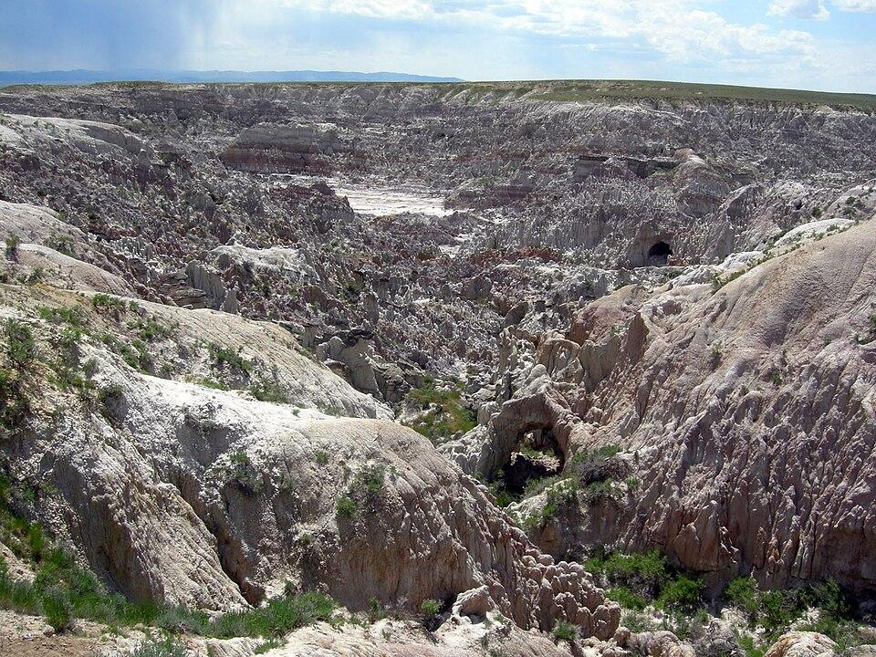 dry landscape of rocks and scrubby plants with a small vally and outcrops