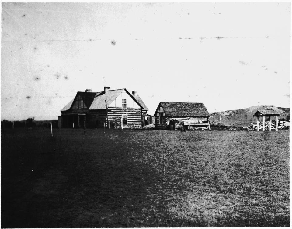 large log houses on an open plain