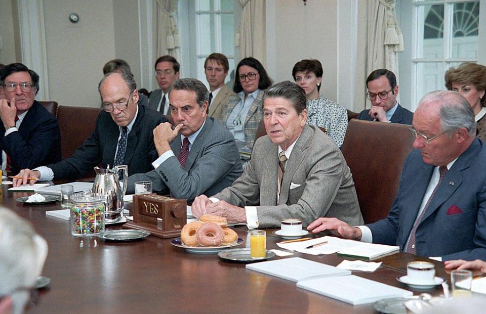 Cabinet meeting of politicians including Alan Simpson and Bob Dole, gathered aroun President Ronald reagan