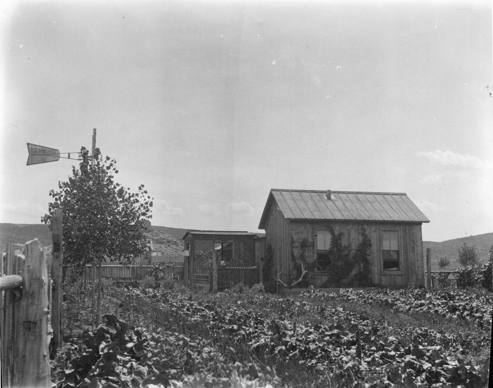 small wood cabin on the plains with a large vegetable garden in the foreground