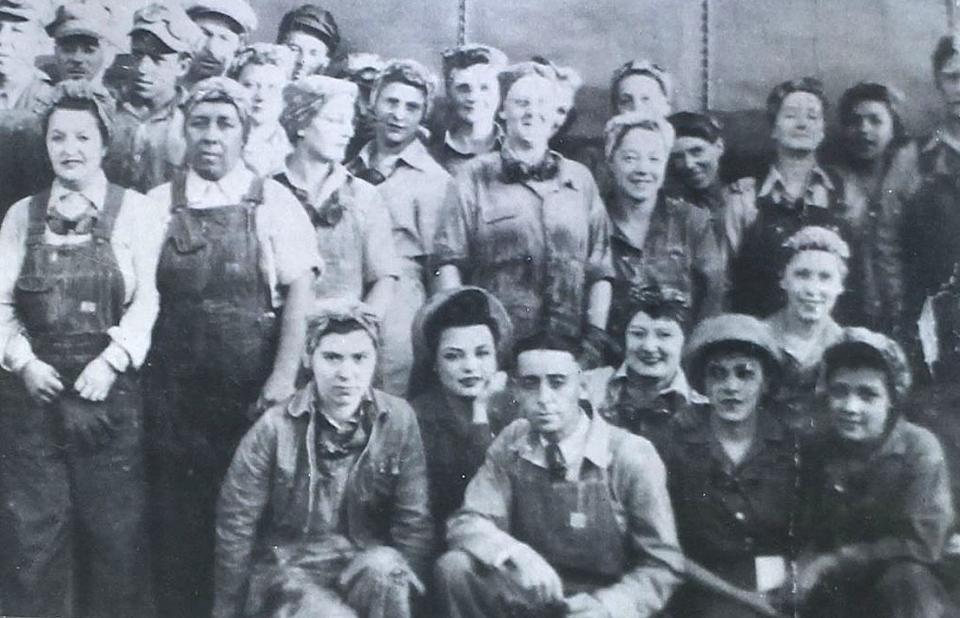 group shot of many men and women in overalls and work clothing