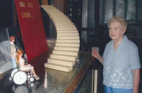 In this undated photo, the author’s aunt, Ruth Thomas, shows visitors at the Stagecoach Museum in Lusk her husband Sam’s custom-made exhibit—so effective in showing how barriers appear to people with mobility challenges. Note the small figures at left, and the open door at the top of the stairs. David L. Roberts photo.