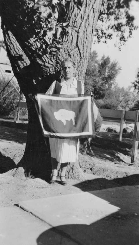 Suffragist, University of Wyoming professor and former Wyoming regent of the D.A.R. Grace Raymond Hebard holds up a state flag in July 1930. The bison in this version faces the viewer’s left—implying that it would fly facing the flagpole—as Hebard demanded. American Heritage Center. Suffragist, University of Wyoming professor and former Wyoming regent of the D.A.R. Grace Raymond Hebard holds up a state flag in July 1930. The bison in this version faces the viewer’s left—implying that it would fly facing the flagpole—as Hebard demanded. American Heritage Center.