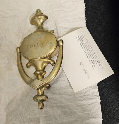 The home meant so much to Hebard that the brass knocker can be found in her papers at the AHC. brass door knocker engraved with the words, "The Doctors Inn"