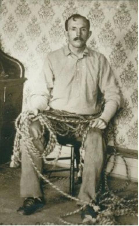 Tom Horn, second person to be executed on the Julian Gallows, poses with his horsehair ropes in the office of the Cheyenne jail. Horn braided ropes while waiting for his execution date. Photo courtesy of the Wyoming State Archives. Tom Horn seated holding a rope