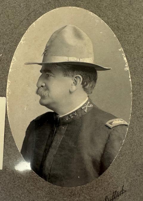Mustachioed man in profile, wearing a cavalry uniform and hat