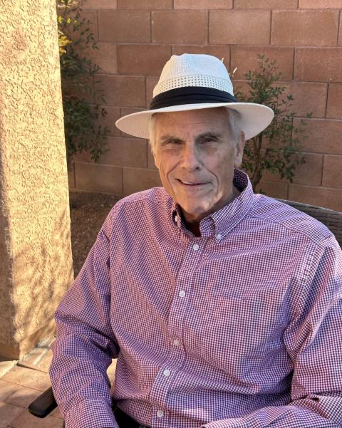 Man in gingham checked shirt wearing a white hat