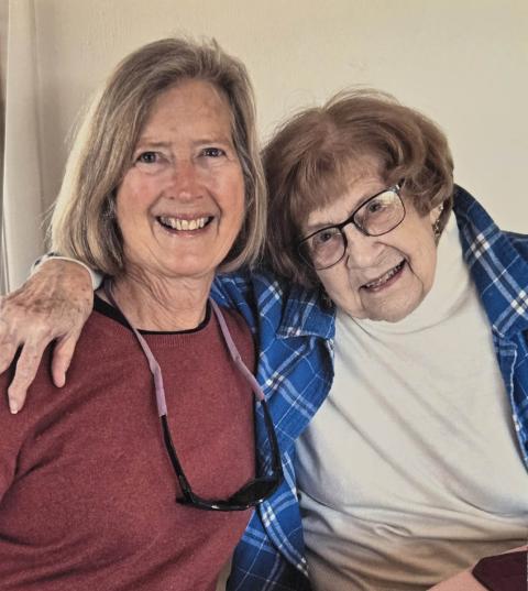 Two women posing for the camera and smiling
