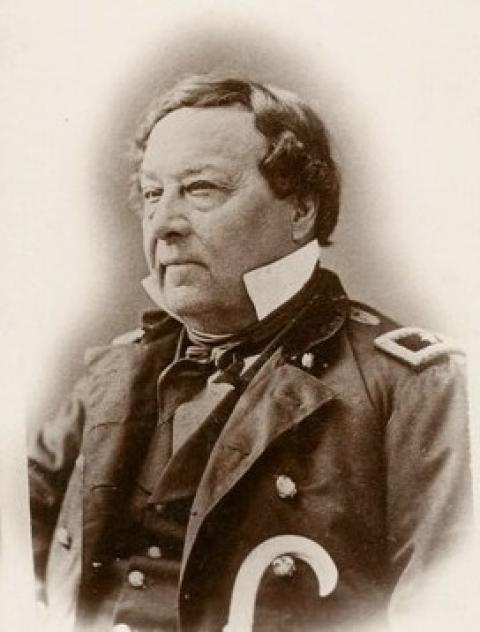 portrait of a heavyset middle-aged white man wearing a high collar, uniform jacket and vest