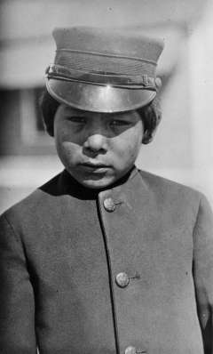 Arapaho schoolboy at the U.S. Government boarding school near Fort Washakie, 1913. Boys at the government school, where treatment was more severe than at the mission schools, wore military uniforms. J.K. Dixon photo, Wyoming Veterans Memorial Museum collections. Arapaho schoolboy at the U.S. Government boarding school near Fort Washakie, 1913. Boys at the government school, where treatment was more severe than at the mission schools, wore military uniforms. J.K. Dixon photo, Wyoming Veterans Memorial Museum collections.